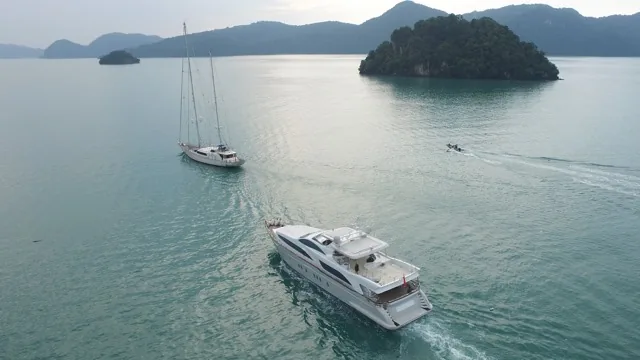 Aerial view of two yachts in a sheltered anchorage beside a wooded island