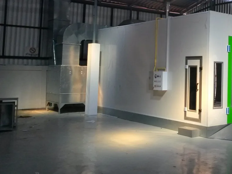 Interior of a marine paint shop: extraction ducting, control panel and the personnel door of an enclosed spray booth